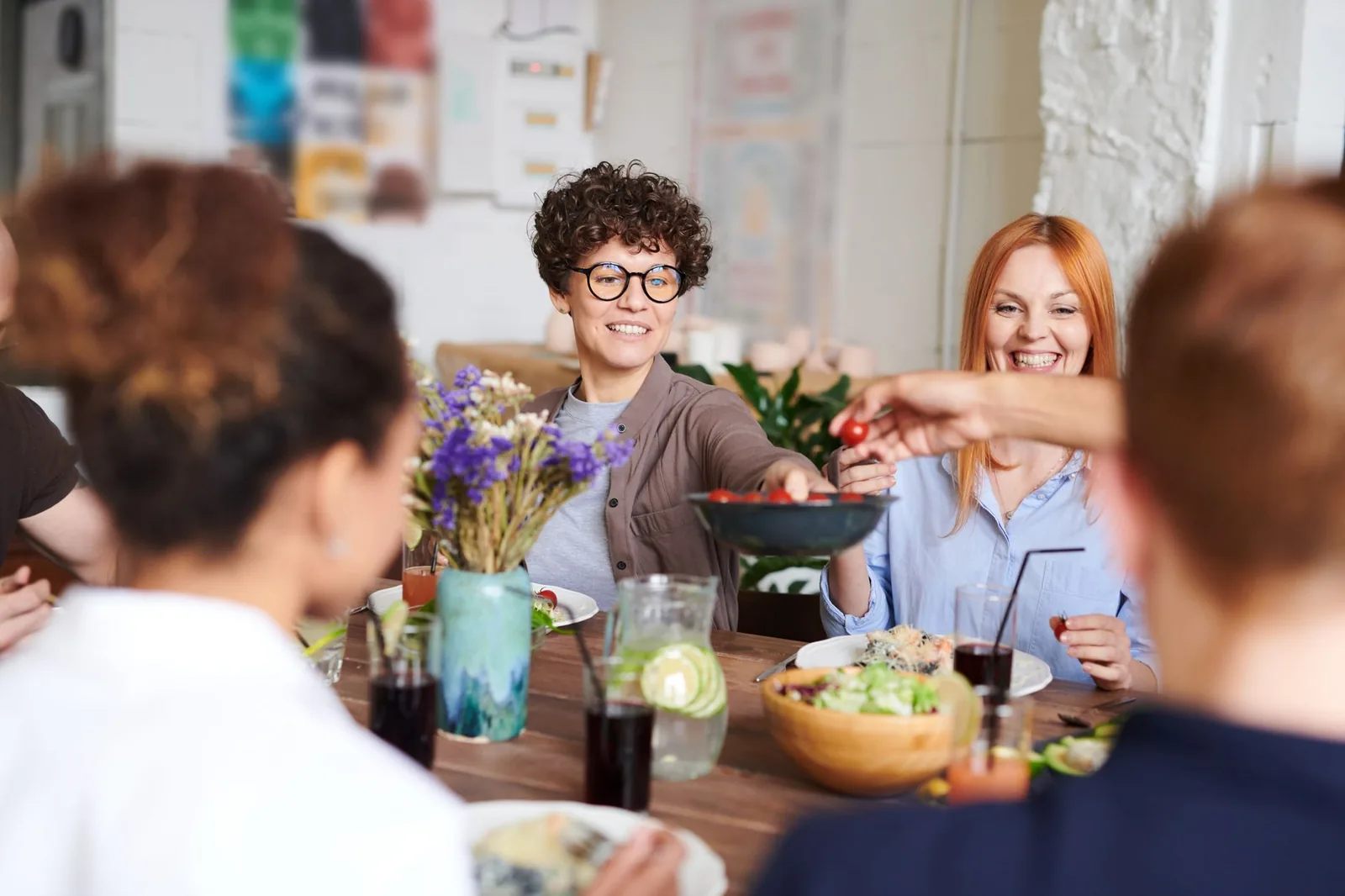 A happy group of friends sharing a casual meal and passing food around a table