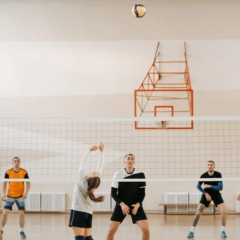 Friends playing an indoor volleyball game